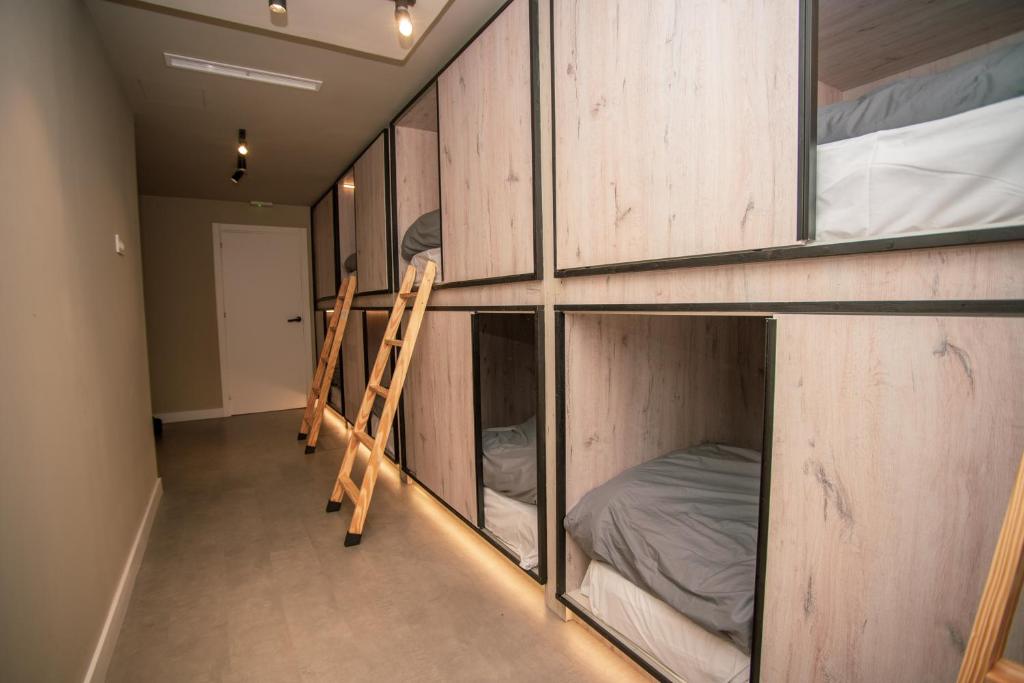 a room with wooden cabinets and a bed and a ladder at Sierra Nevada Hostel in Sierra Nevada