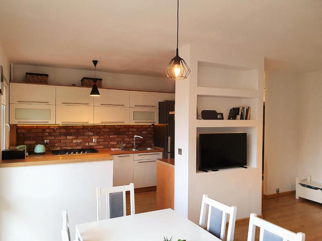 a kitchen and dining room with a white table and chairs at Happy Stay in Gliwice