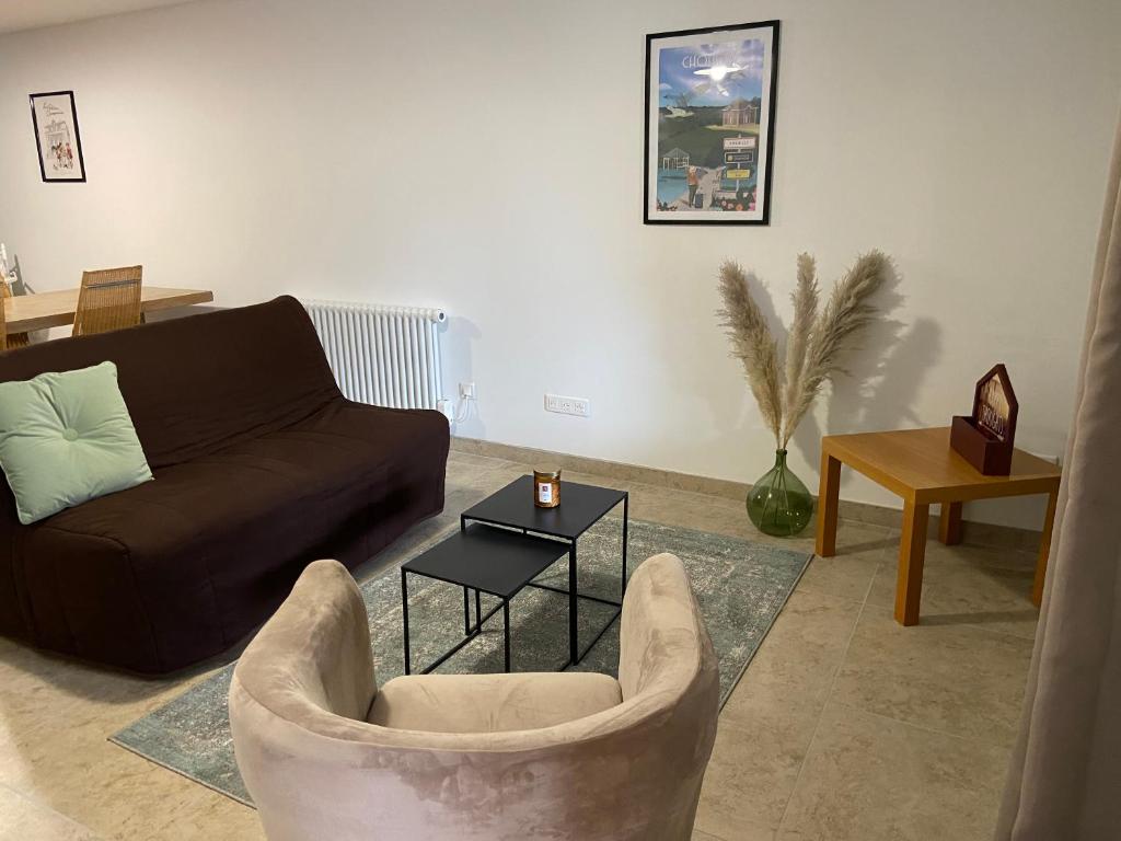 salon z kanapą i stołem w obiekcie Gîte La Hallette au cœur du vignoble Champenois, classé 2 étoiles w mieście Chouilly