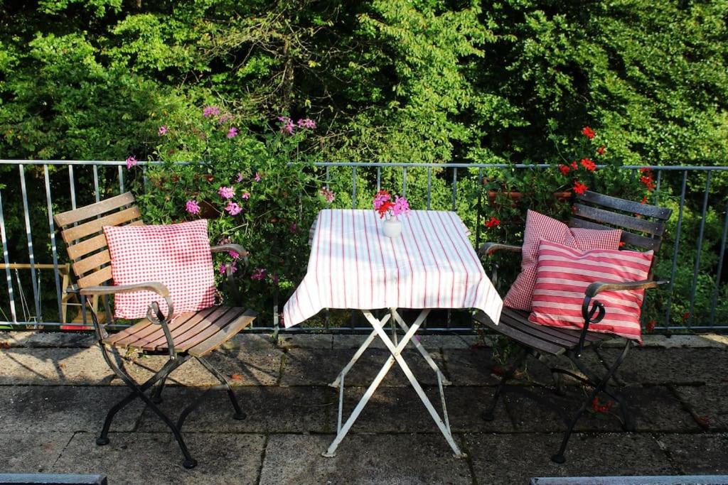 uma mesa e duas cadeiras com almofadas em Wohnung mit Dachterrasse in Starnberg em Starnberg