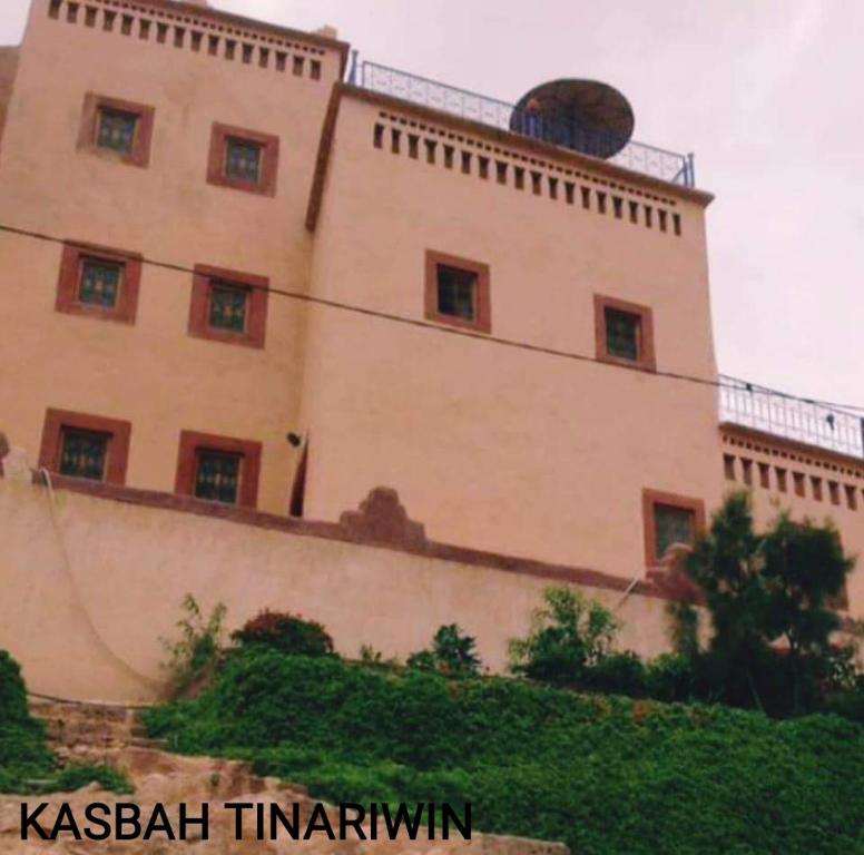 un grand bâtiment au sommet d'une colline dans l'établissement Kasbah Tinariwin, à Taziricht