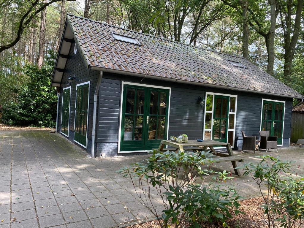una pequeña casa con una mesa de picnic delante de ella en 't Wettenshuys, en Nuenen