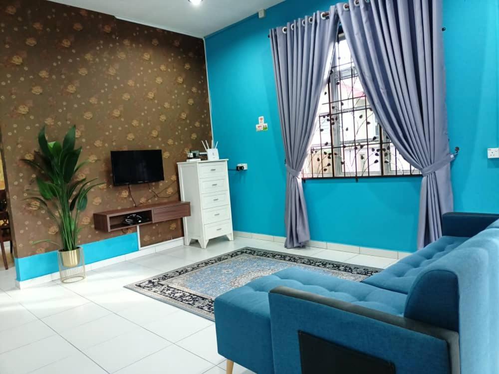 a blue living room with a blue couch and a window at Homestay Kemaman Private Pool Fyna in Kemaman