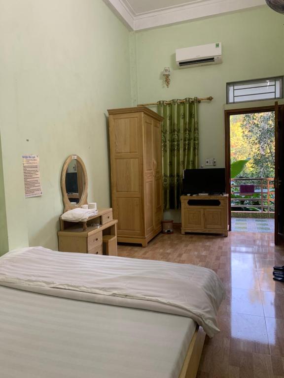 a bedroom with a bed and a tv and a mirror at Như Quỳnh Hotel in Bảo Lạc
