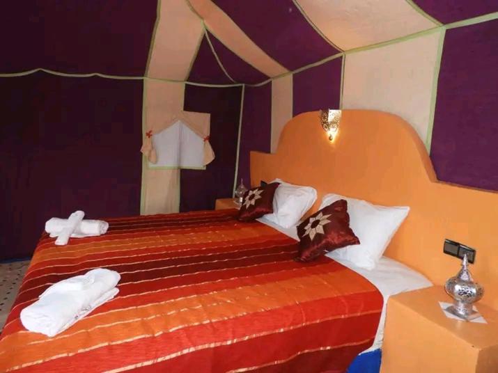 een slaapkamer met een bed met handdoeken erop bij top luxury desert camp in Erfoud