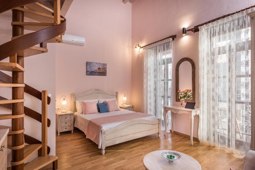una camera con letto e scala a chiocciola di Palazzo di Irene a Chania