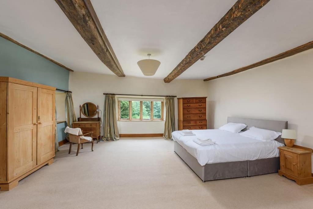 Un dormitorio grande con una cama grande y una ventana. en 10 Bed Stunning House in village, with Hot Tub, en Ovingham