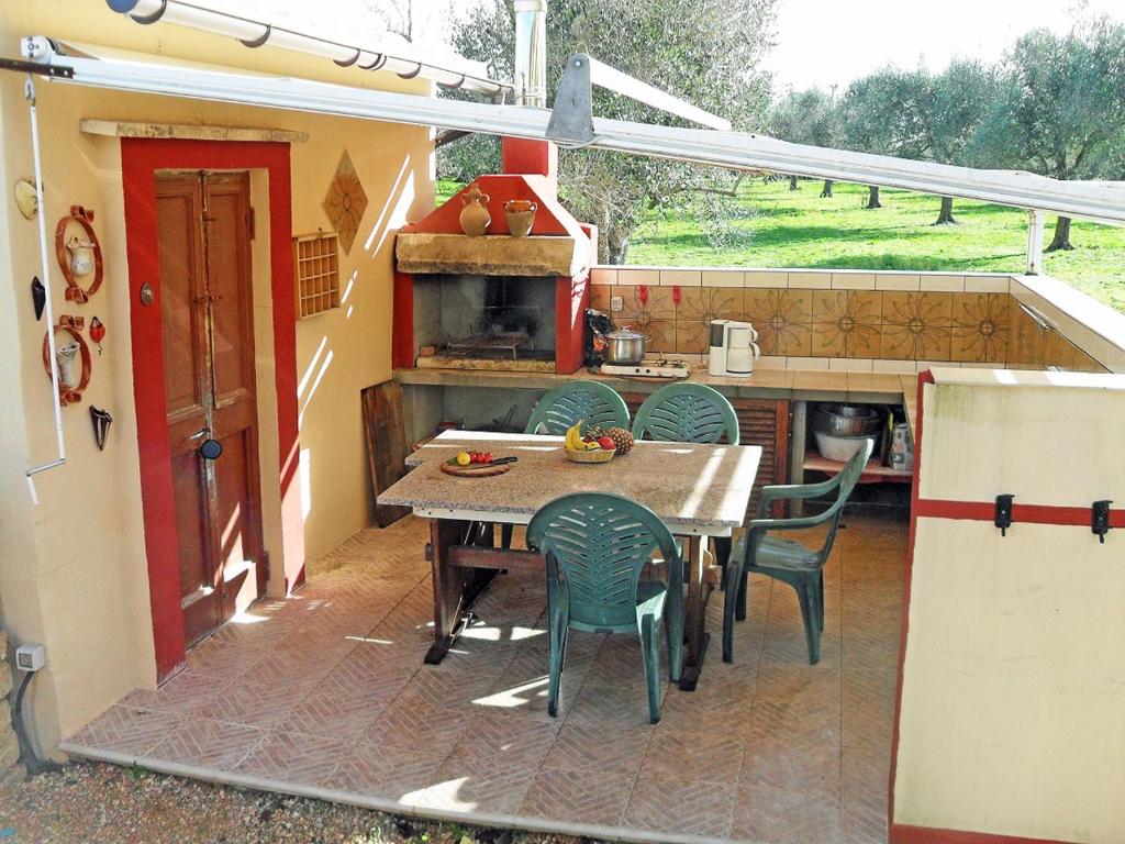 patio con mesa y sillas y cocina en Camping Terreno-Ro-Bi-Li, en Cutrofiano