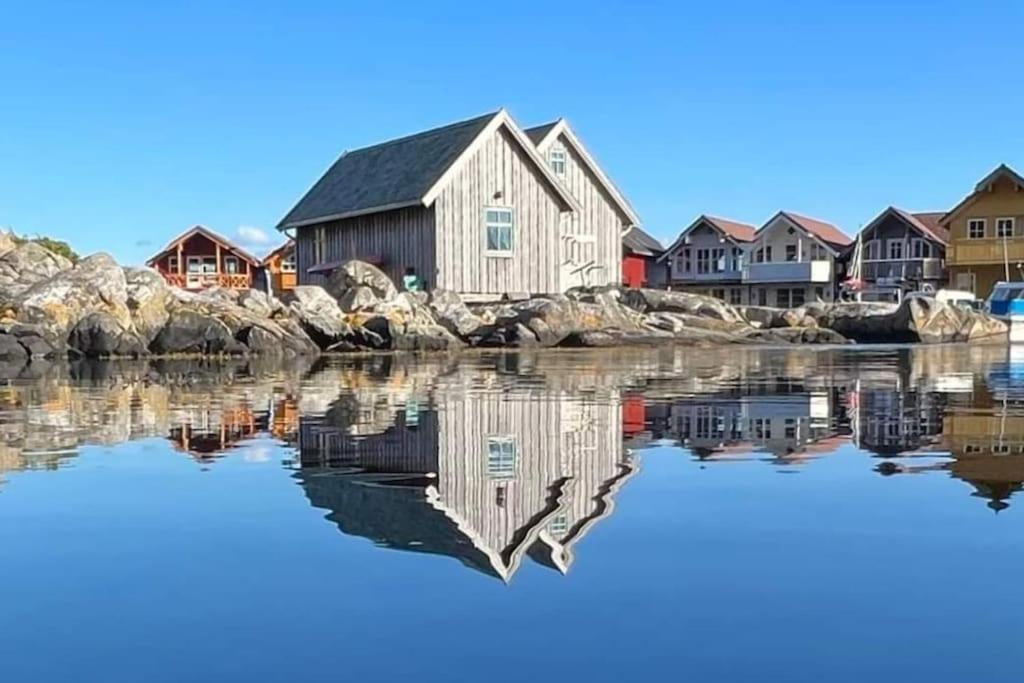 una casa en el agua junto a algunas rocas en Cottage 2 meters from the sea, Bekkjarvik, 60 km from Bergen, 