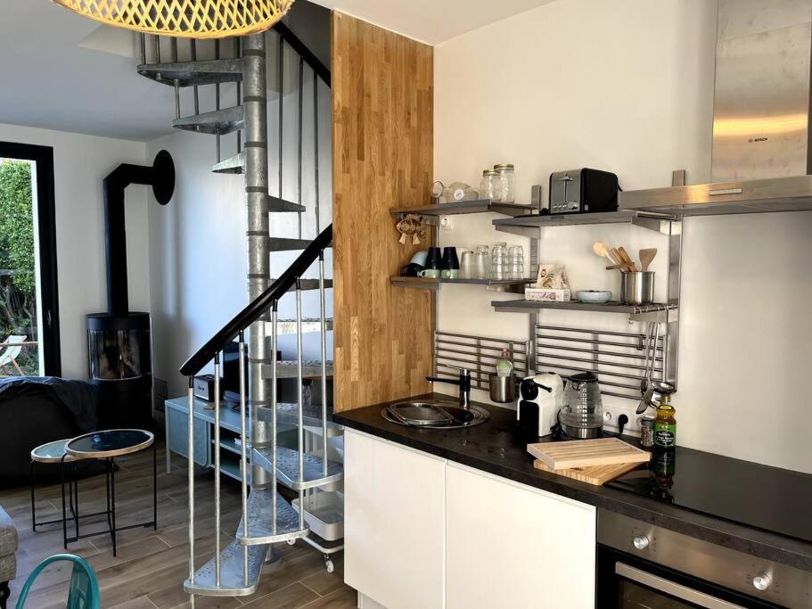 una cucina con bancone e scala a chiocciola di LA CABINE VUE MER a Luc-sur-Mer