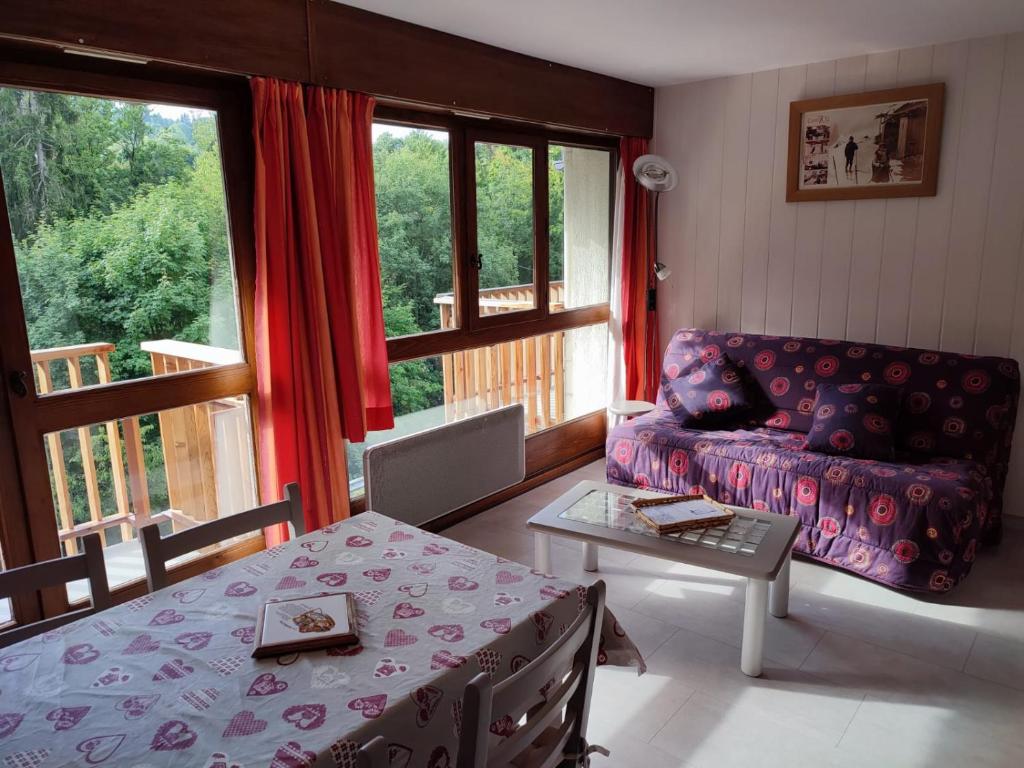 una sala de estar con un sofá y una mesa en Coquet Studio de 4 personnes aux Carroz - Balcon et Wifi, en Les Carroz d'Araches