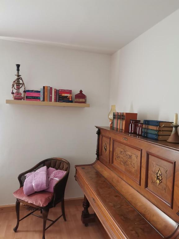 a room with a wooden piano and a chair at Auszeit in Freital