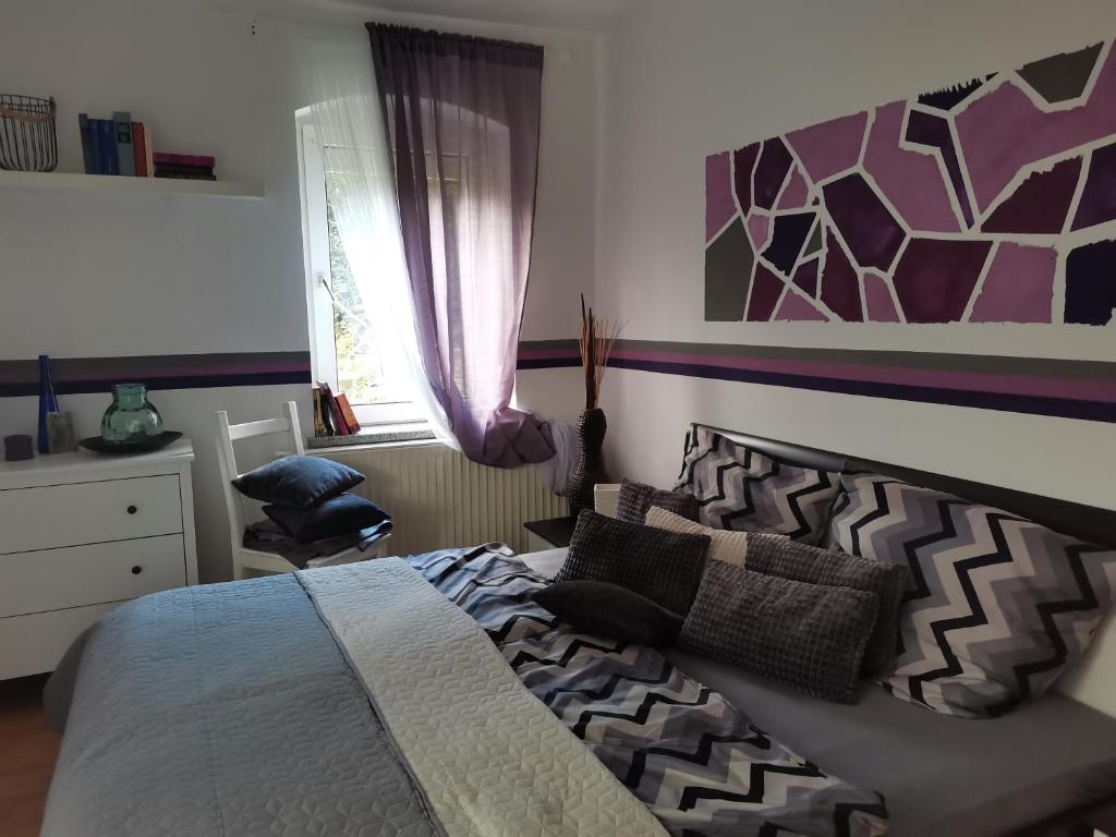 a bedroom with a bed and a chair and a window at Auszeit in Freital