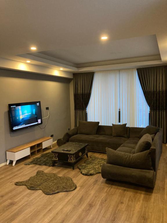 a living room with a couch and a flat screen tv at Aryan Suit. in Istanbul
