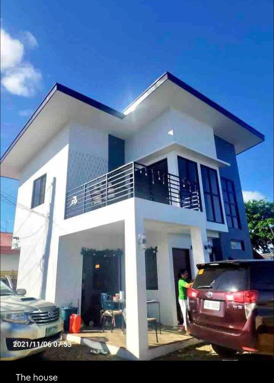 a man standing in front of a white house at Sea Breeze Beach House near sandbars and beaches and near to Danao port in Alimañgo