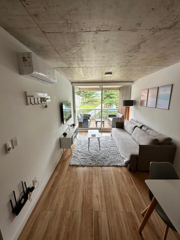 sala de estar con sofá y mesa en Apartamento a estrenar en complejo Mansa inn2 en Punta del Este