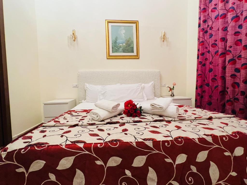 ローマにあるAffitacamere Radiのベッドルーム1室(大型ベッド1台、赤と白の毛布付)
