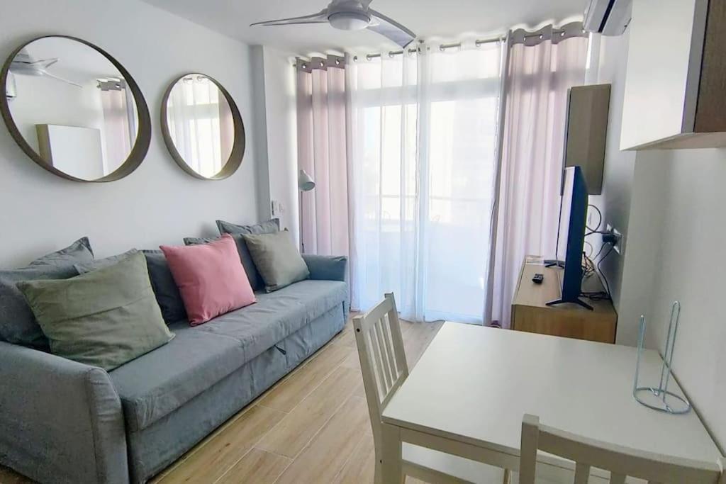 salon z kanapą, stołem i lustrem w obiekcie Pequeño y acogedor 4th w mieście Playa del Ingles