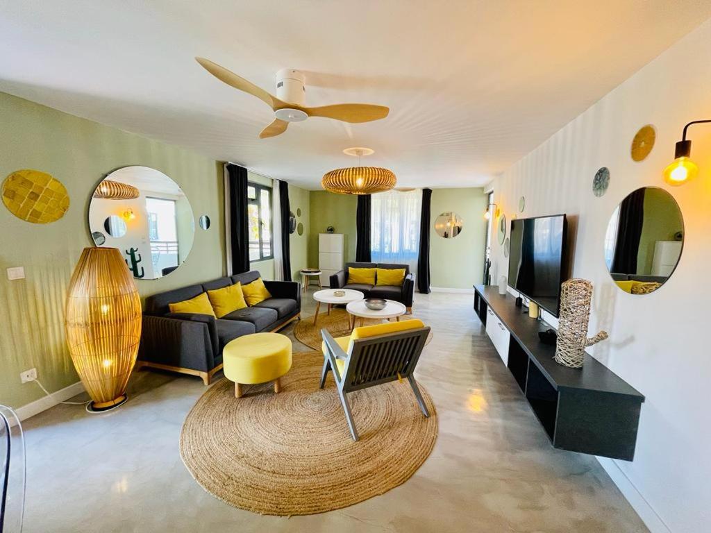 a living room with a couch and a table at LUXURY MODERN apartment - Excellent location 50m from the beach, restaurants, bars, shops in Flic-en-Flac