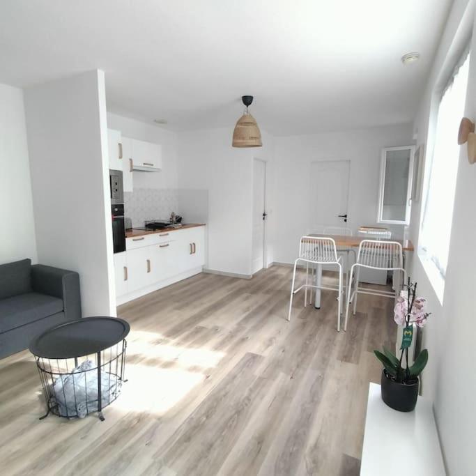 un soggiorno con divano e tavolo di Spacieux studio dans résidence avec parking privé a Clermont-Ferrand