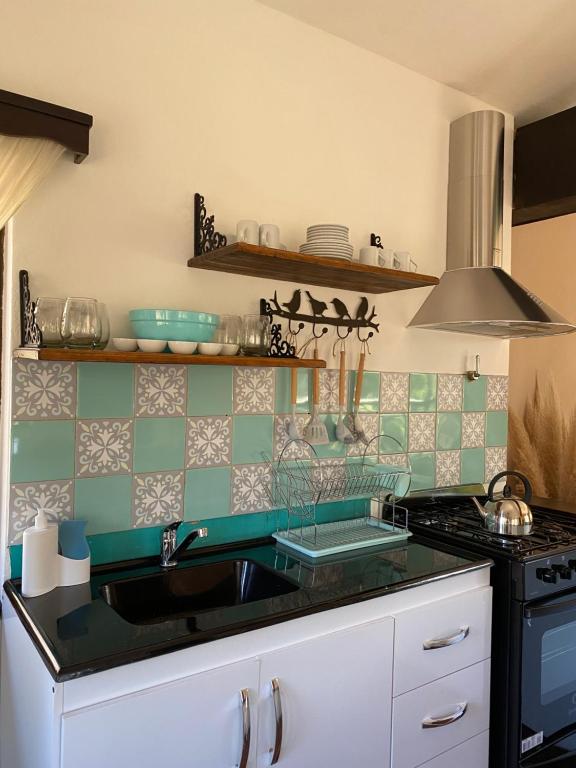 a kitchen with a sink and a stove at El gran roble in La Cumbrecita