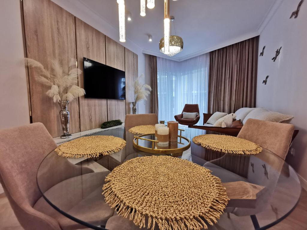 a living room with two tables and a couch at Gold Apartment B33 Let's Sea Baltic Park Gąski in Gąski