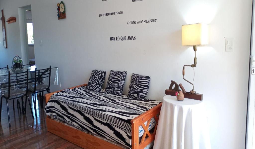 una camera con un letto e un tavolo con una lampada di Apartamento Varetto a Sierra de los Padres