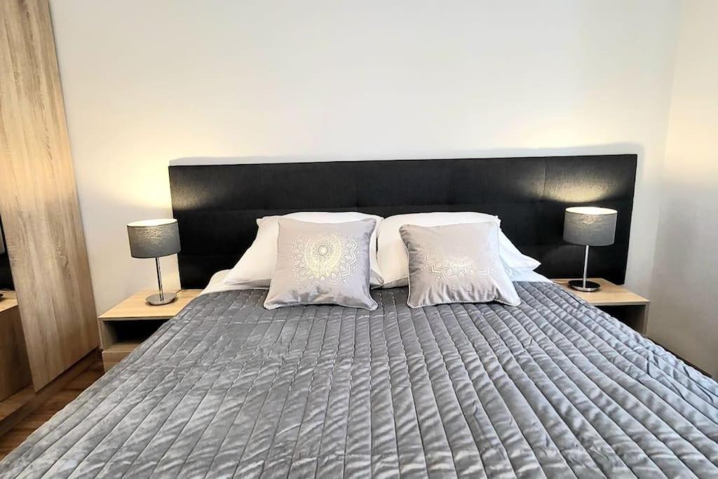 a large bed with two pillows and two lamps at Modern Silver Apartment 2 rooms Bosacka Old Town in Krakow