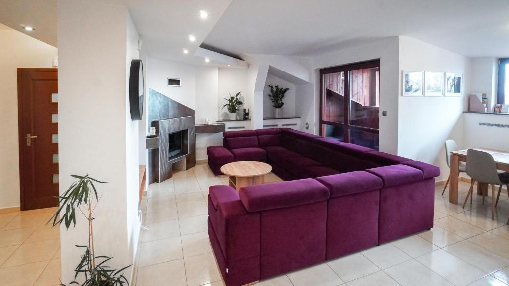a living room with a purple couch and a table at Apartament Wschodnia in Lublin