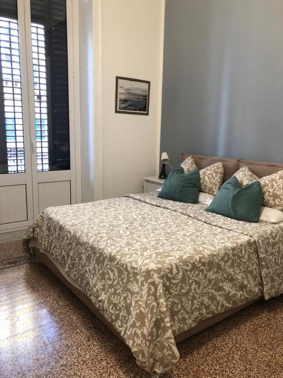 Un dormitorio con una cama grande con almohadas verdes. en La Bella Balla-rò Rooms, en Palermo