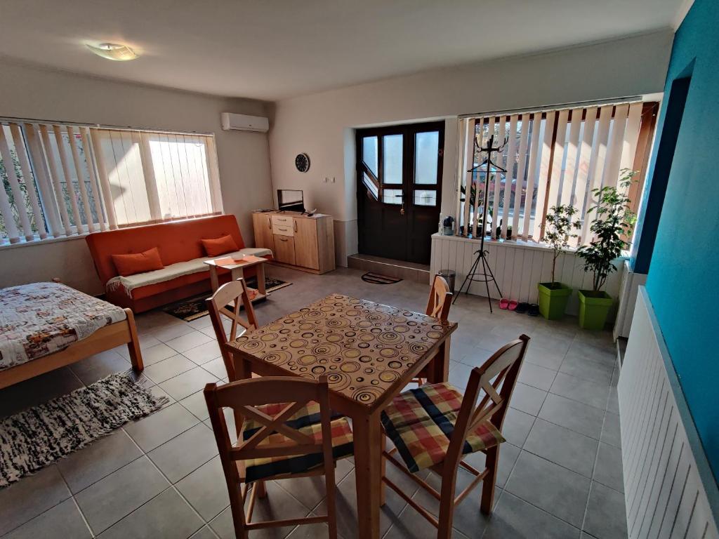 sala de estar con mesa, sillas y sofá en Apartman Ankica, en Golubac