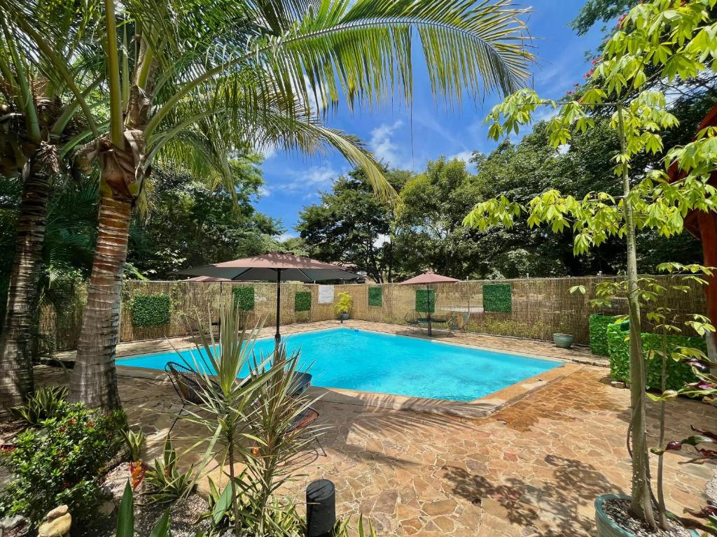 una piscina en un jardín con palmeras en Casa Tropical Playa Grande en Cuajiniquil