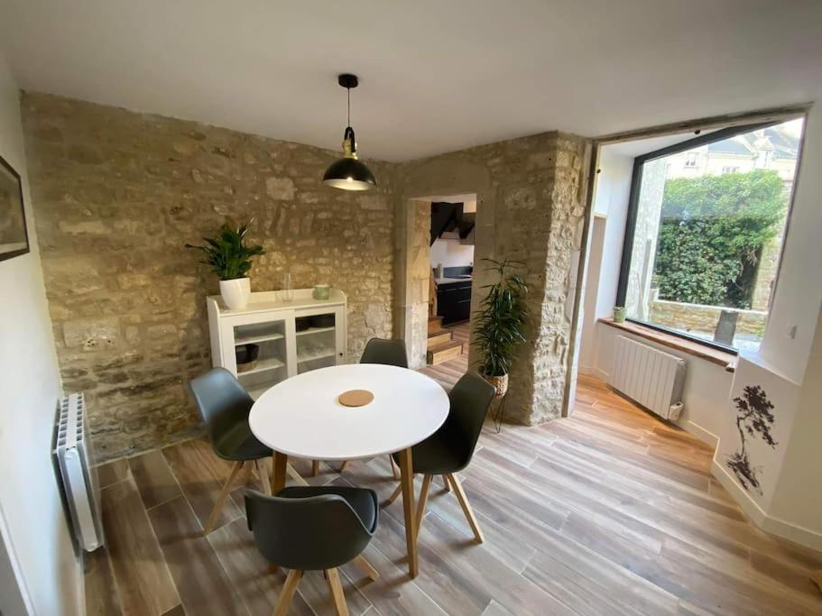 ein Esszimmer mit einem weißen Tisch und Stühlen in der Unterkunft Appartement centre-ville de Valognes in Valognes