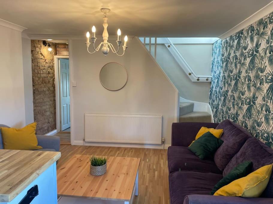 ein Wohnzimmer mit einem Sofa und einem Tisch in der Unterkunft Stylish & Spacious 2 Storey, 3 Bed Apartment in Kent