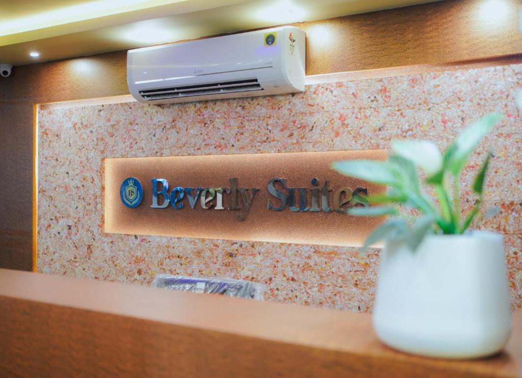 a sign for a beauty clinic with a flower in a vase at BEVERLY SUITES in Wayanad