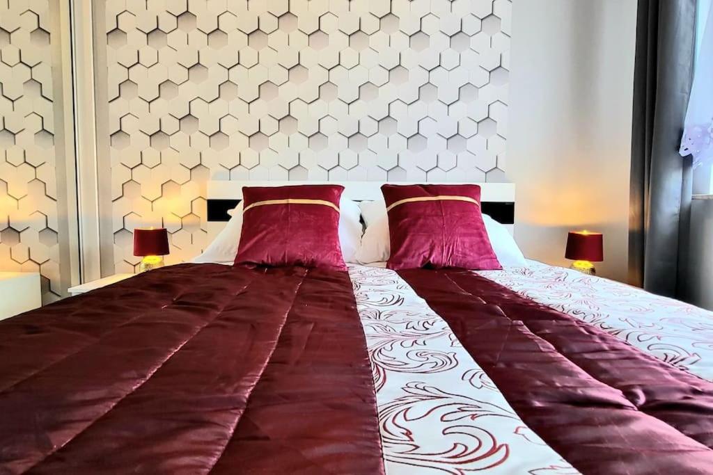 a bedroom with a large bed with pink pillows at Cozy RED ROSE Apartment, 2 rooms Down Town in Kraków