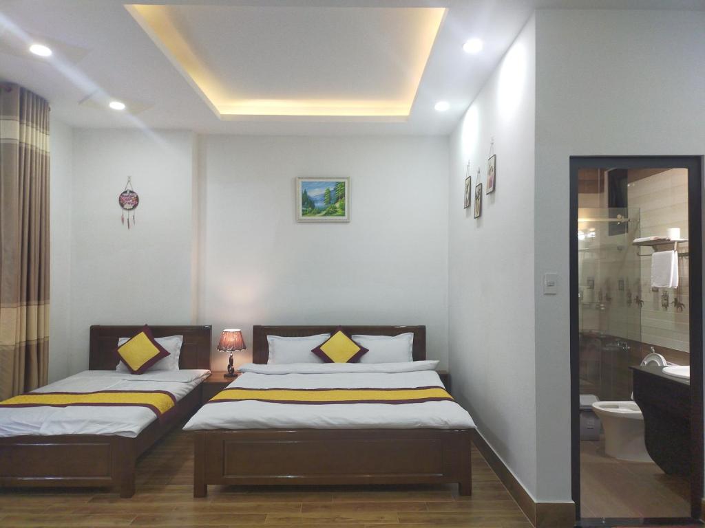1 dormitorio con 2 camas y baño en NHÀ GÓC PHỐ Đà Lạt, en Da Lat