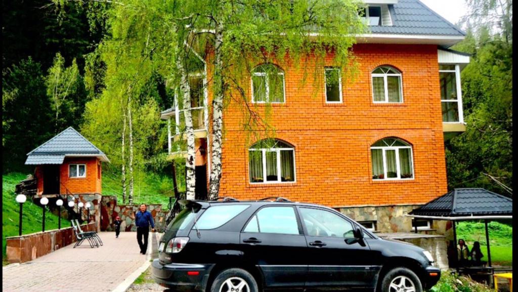 a black suv parked in front of a house at Горная Сказка in Besqaynar