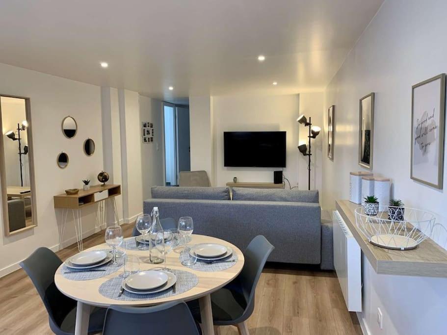 sala de estar con mesa y sofá en Appartement moderne avec parking gratuit, en Dinsheim
