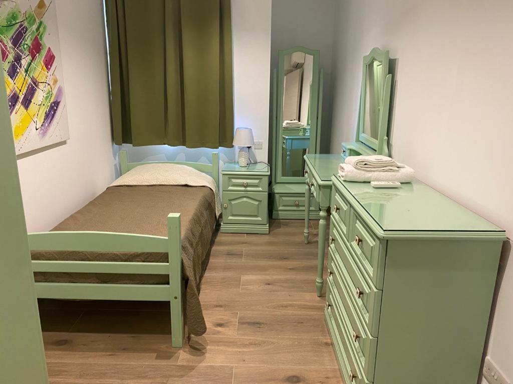 um quarto com cómodas verdes e uma cama e espelhos em Sliema Living em Sliema