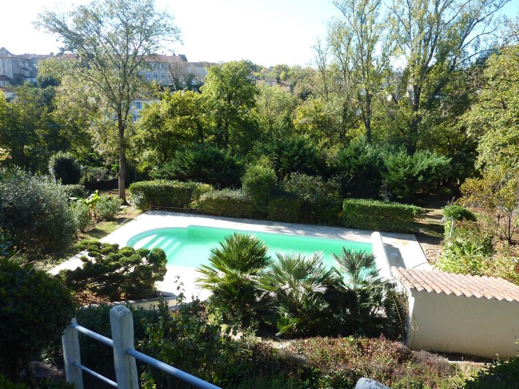 une piscine dans un jardin avec des arbres et des buissons dans l'établissement Beaux Chênes, à Nérac