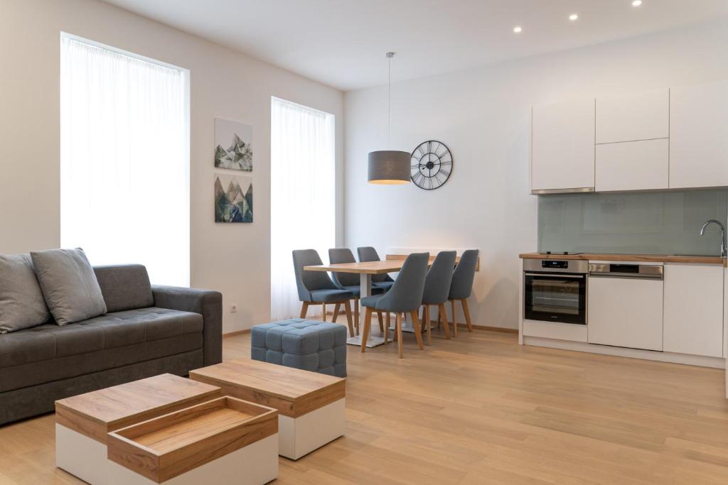 ein Wohnzimmer mit einem Sofa und einem Tisch mit Stühlen in der Unterkunft Modern 3 room apartment in a prime location in Wien
