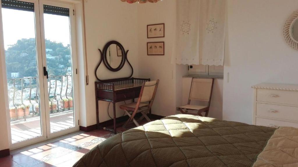 - une chambre avec un lit, un bureau et un miroir dans l'établissement Sunshine, à Capri