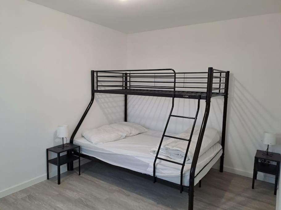 ein schwarzes Etagenbett mit einer Leiter und zwei Nachttischen in der Unterkunft Petite maison en bord de Loir in La Flèche