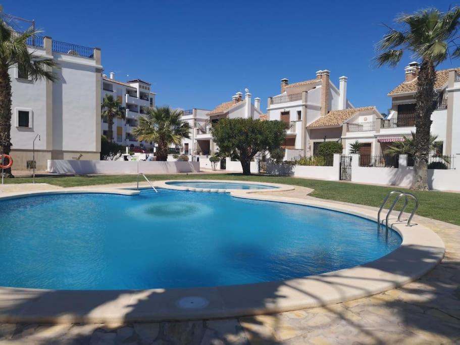 een groot zwembad voor een aantal huizen bij Casa JC in Orihuela