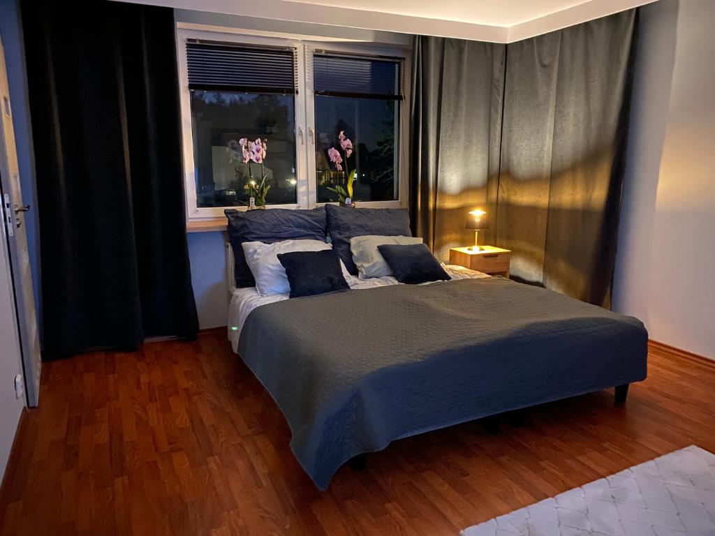 ein Schlafzimmer mit einem Bett und einem Fenster mit Blumen in der Unterkunft Amonit in Olsztyn