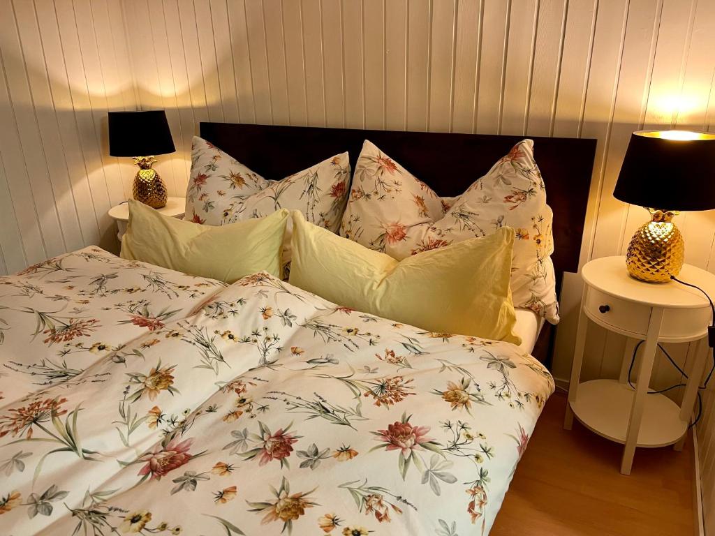 a bed with a floral comforter and pillows at Charming Apartment with Mountain View in Altmünster