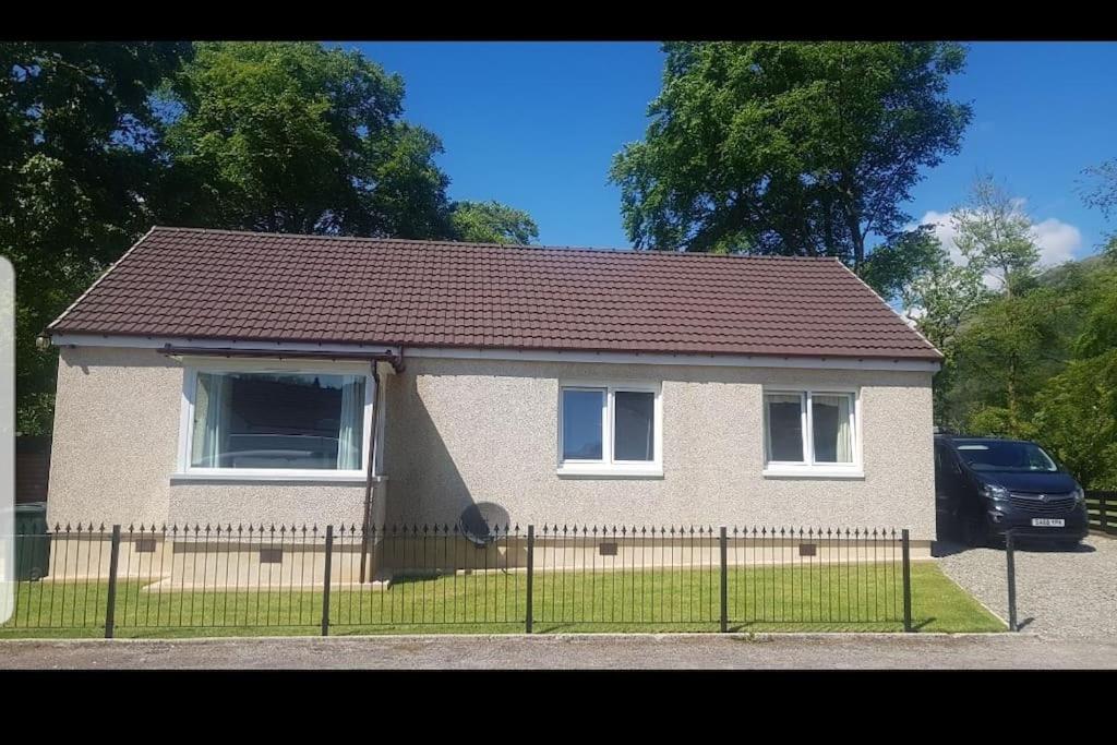 a house with a fence in front of it at Stunning views in Lochgoilhead