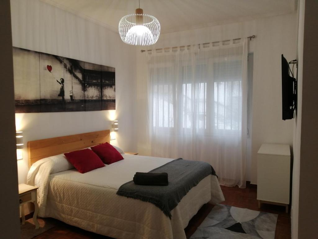 1 dormitorio con 1 cama grande con almohadas rojas en Piso luminoso, amplio y tranquilo en Casco Viejo, en Bilbao