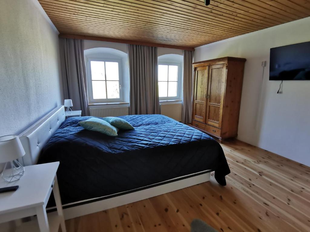 a bedroom with a bed with blue sheets and two pillows at Ferdlhof Ferienwohnung in Ulrichsberg